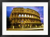 Low angle view of the old ruins of an amphitheater lit up at dusk, Colosseum, Rome, Italy Framed Print