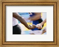 Mid section view of runners exchanging baton at a relay race Fine Art Print