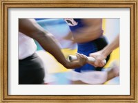 Mid section view of runners exchanging baton at a relay race Fine Art Print