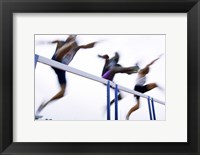 Low angle view of three men jumping over a hurdle Fine Art Print