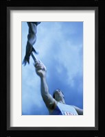 Low angle view of runners passing a baton in a relay race Fine Art Print