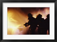 Firefighters extinguishing a fire Framed Print