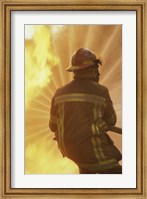 Rear view of a firefighter extinguishing a fire Fine Art Print