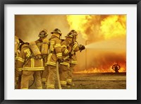 Rear view of a group of firefighters extinguishing a fire Fine Art Print