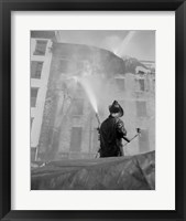 Firefighter pouring water on burning building, low angle view Fine Art Print