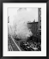 New York City, Fire on East 47th Street, with fire engines shooting water on burning building Framed Print