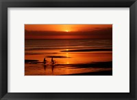Silhouette of a young couple cycling on the beach Fine Art Print