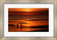 Silhouette of a young couple cycling on the beach Fine Art Print