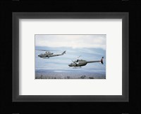 A left side view of an AH-1 Cobra helicopter, front, and an OH-58 Kiowa helicopter Framed Print