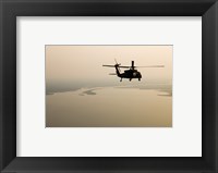 An Air Force helicopter flys over Lake Pontchatrain to New Orleans Framed Print