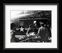 Army soldiers carrying an injured person in a helicopter Fine Art Print
