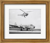 Low angle view of a helicopter in flight and an airplane at an airport, Sikorsky Helicopter, Douglas DC-4 Fine Art Print