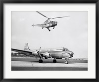 Low angle view of a helicopter in flight and an airplane at an airport, Sikorsky Helicopter, Douglas DC-4 Fine Art Print