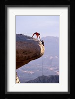 Side profile of a young man pulling a young woman onto a rock Fine Art Print