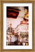 A Young Girl Praying in Front of a Giant Buddha Statue Fine Art Print