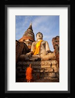 Monk praying in front of a statue of Buddha Fine Art Print