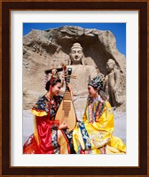 Two girls in traditional costumes in front of the Buddha Statue, China Fine Art Print