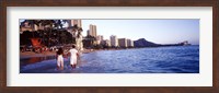 Rear view of a couple wading on the beach, Waikiki Beach, Honolulu, Oahu, Hawaii, USA Fine Art Print