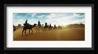 Tourists riding camels through the Sahara Desert landscape led by a Berber man, Morocco Fine Art Print