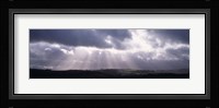 Sunbeams radiating through dark clouds over rolling hills, Dartmoor, Devon, England Fine Art Print