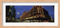 Low angle view of buildings lit up at night, Harrods, London, England Fine Art Print
