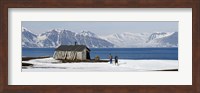Two hikers standing on the beach near a hunting cabin, Bellsund, Spitsbergen, Svalbard Islands, Norway Fine Art Print