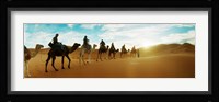 Tourists riding camels through the Sahara Desert landscape led by a Berber man, Morocco Fine Art Print