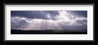 Sunbeams radiating through dark clouds over rolling hills, Dartmoor, Devon, England Fine Art Print