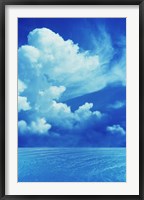 White clouds in dark blue sky over rippling water Fine Art Print