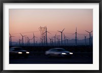 Cars moving on road with wind turbines in background at dusk, Palm Springs, Riverside County, California, USA Framed Print