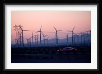Car moving on a road with wind turbines in background at dusk, Palm Springs, Riverside County, California, USA Framed Print