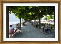 People sitting on benches among trees at lakeshore, Lake Como, Cernobbio, Lombardy, Italy Fine Art Print