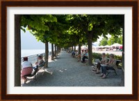 People sitting on benches among trees at lakeshore, Lake Como, Cernobbio, Lombardy, Italy Fine Art Print