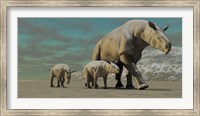 A Paraceratherium mother with two twin calves walks along a desert Fine Art Print