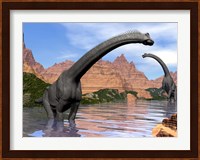 Two Brachiosaurus dinosaurs in water next to red rock mountains Fine Art Print