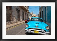 Cuba, Camaquey, Oldsmobile car and buildings Fine Art Print
