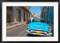 Cuba, Camaquey, Oldsmobile car and buildings Fine Art Print