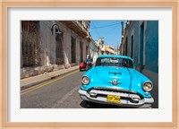 Cuba, Camaquey, Oldsmobile car and buildings Fine Art Print