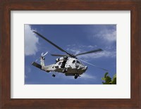 A Crew Chief looks out the side door of a helicopter in flight Fine Art Print