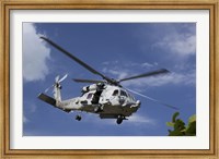 A Crew Chief looks out the side door of a helicopter in flight Fine Art Print