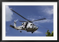 A Crew Chief looks out the side door of a helicopter in flight Fine Art Print
