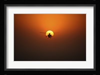 An AH-64D Apache Helicopter Flying into the Sun over Iraq Fine Art Print
