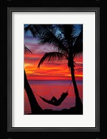 Woman in hammock, and palm trees at sunset, Fiji Framed Print