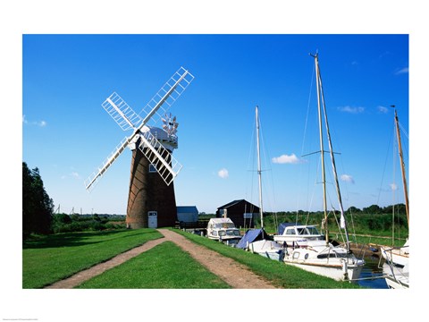 Framed Boat moored near a traditional windmill, River Ant, Norfolk Broads, Norfolk, England Print