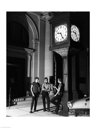 Framed Young men standing below clock at night Print