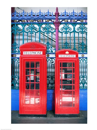 Framed Two telephone booths near a grille, London, England Print