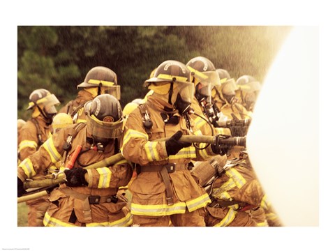 Framed Group of firefighters spraying water with a fire hose Print