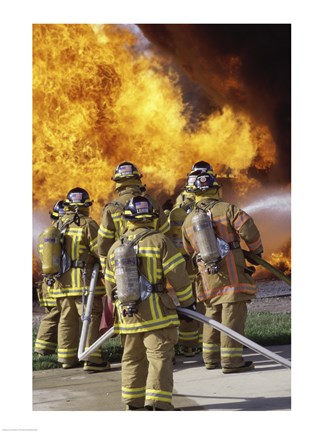 Framed Rear view of a group of firefighters extinguishing a fire vertical Print