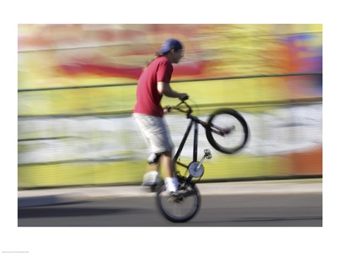 Framed Side profile of a teenage boy performing a stunt on a bicycle Print