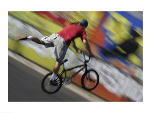 Framed Rear view of a teenage boy performing a stunt on a bicycle Print